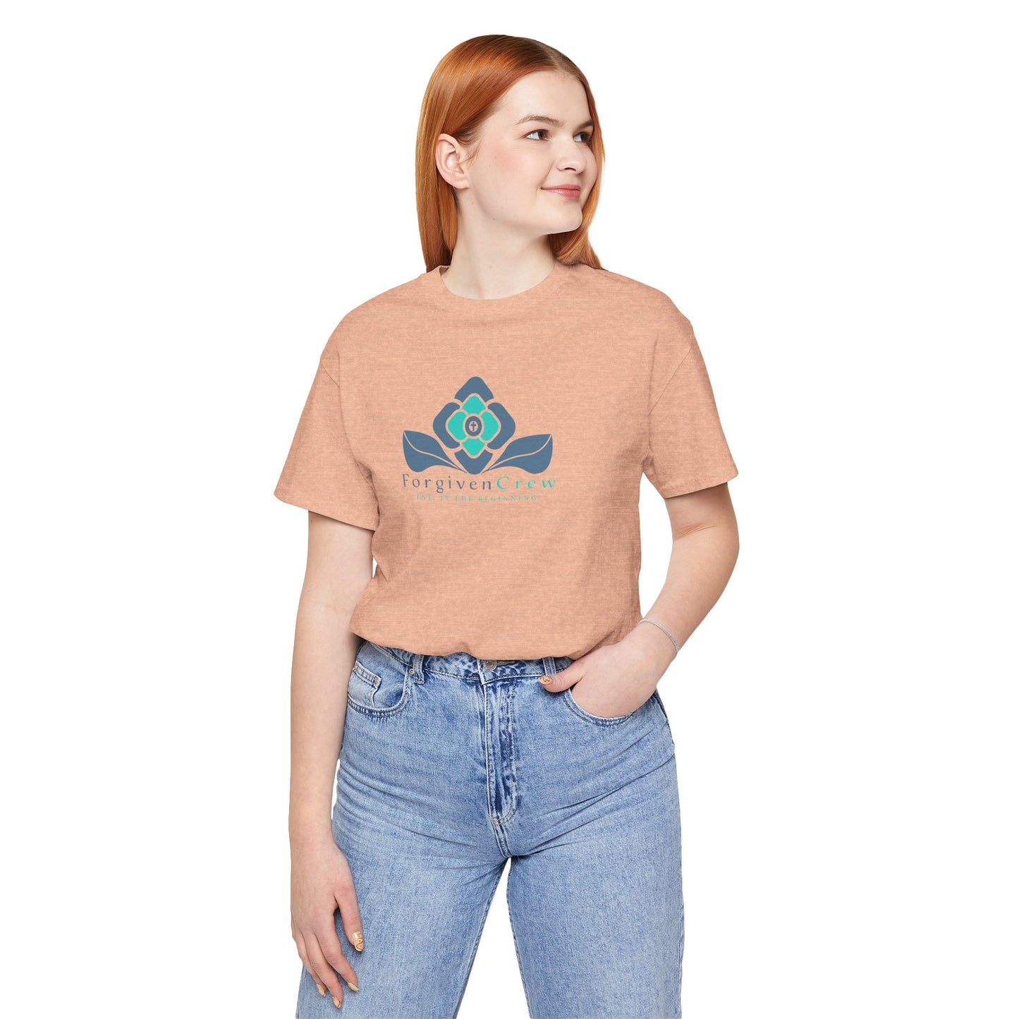 Forgiven Crew Christian Clothing Model showing the front of the peach christian t-shirt, Christian shirt has a blue 2 tones flower with forgiven crew and est. in the beginning printed below the flower